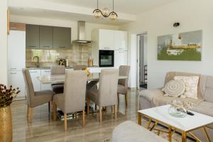 eine Küche und ein Wohnzimmer mit einem Tisch und einer Couch in der Unterkunft Villa Nadalina, Cista Provo in Lovreć