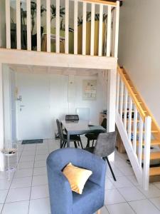 ein Wohnzimmer mit einem blauen Stuhl und einem Tisch in der Unterkunft LaConciergerieJonzac Appart 1 chambre Cocooning in Jonzac