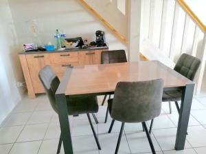 a kitchen with a wooden table and chairs at Appartement 1 chambre "Cocooning" in Jonzac +3 photos