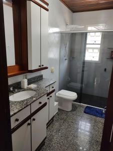 ein Bad mit einem WC, einem Waschbecken und einer Dusche in der Unterkunft Quarto na Casa dos Bolzoni in Nova Prata