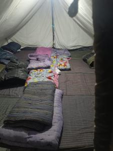 a group of blankets and pillows on a bed in a tent at GarhKumoan in Kedārnāth