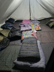 a group of blankets laying on the floor of a tent at GarhKumoan in Kedārnāth