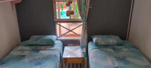 two beds in a room with a window at Cunumí in Puerto Iguazú