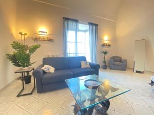 un soggiorno con divano blu e tavolo in vetro di Suite Palazzo Capri - Seaview a Capri