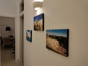 four pictures are hanging on a wall at Sunset Ortigia-locazione turistica in Syracuse