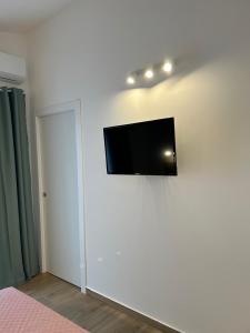 TV de pantalla plana colgada en una pared blanca en Etna sicula, en San Giovanni la Punta