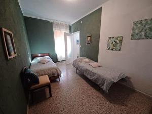 a bedroom with two beds and a chair in it at La Casa Rossa -Dimora di campagna in Montechiaro D'acqui