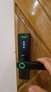 a person unlocking a door with a green light at Feliz descanso-acogedor/moderno in Tarija