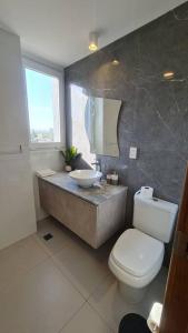 a bathroom with a white toilet and a sink at Feliz descanso-acogedor/moderno in Tarija