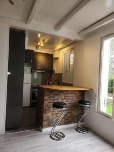 eine Küche mit einer Theke mit zwei Hockern in der Unterkunft bel appartement in Villeneuve-Saint-Georges