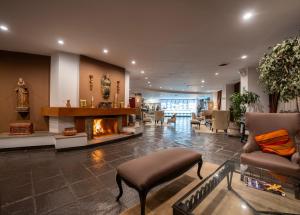 a lobby with a fireplace and a couch and chairs at Hotel Jose Antonio Cusco in Cusco