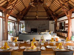 a dining room with a long table and a couch at Villa Lilibel by Elite Havens in Seminyak