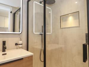 ein Bad mit einer Dusche und einem Waschbecken in der Unterkunft Skylight Retreat in Carnforth