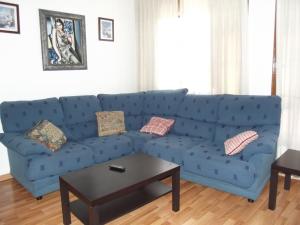 a blue couch in a living room with a table at Pensión Sandoval in León