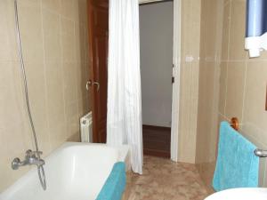 a bathroom with a white tub and a shower at Pensión Sandoval in León