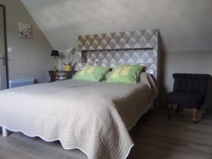 a bedroom with a large bed and a chair at Les Gites de Kerdurod in Guidel
