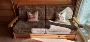 a couch with two pillows on it in a room at Kleine Wohnung in Tiefenbach mit Sauna und Schwimmbad in Oberstdorf