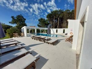 a patio with lounge chairs and a swimming pool at Vila Louro in Santa Cruz