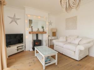 a living room with a white couch and a fireplace at 12 Pennystone Road in Blackpool