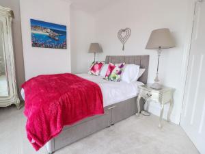 a bedroom with a bed with a red blanket on it at 12 Pennystone Road in Blackpool