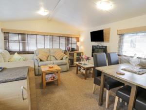 a living room with a couch and a table at Middlemuir Retreat in Tarbolton