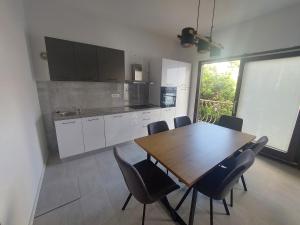 Una cocina con una mesa de comedor y sillas de madera. en Apartman Lili Podgora, en Podgora