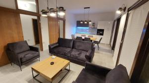 Una sala de estar con un sofá y sillas y una mesa. en Apartman Lili Podgora, en Podgora