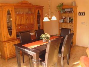 - une salle à manger avec une table et des chaises en bois dans l'établissement Komfortables Ferienhaus in Heidmühle mit Terrasse, Garten und Grill, à Schortens