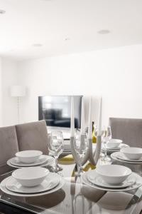 uma mesa de jantar com pratos e copos de vinho em Luxury 3Bed 2Bath-London Marylebone Station em Londres