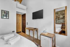 a white bedroom with a bed and a television at Vila Meri in Berat