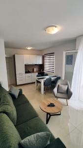 een woonkamer met een groene bank en een tafel bij Apartments Rodin in Trogir