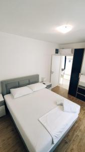 een slaapkamer met een groot wit bed met witte lakens bij Apartments Rodin in Trogir