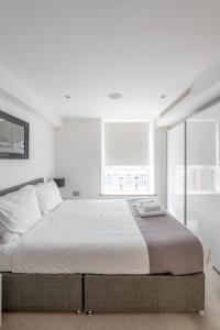 um quarto branco com uma cama grande e 2 janelas em Luxury 3Bed 2Bath-London Marylebone Station em Londres