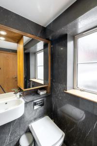 uma casa de banho com um WC, um lavatório e um espelho. em Luxury 3Bed 2Bath-London Marylebone Station em Londres