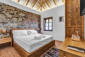 a bedroom with a bed and a brick wall at Vila Meri in Berat