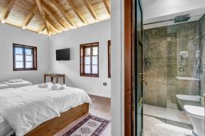 a bedroom with a bed and a glass shower at Vila Meri in Berat