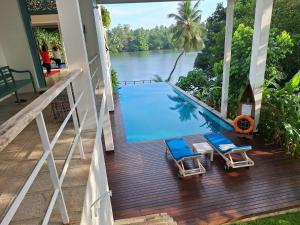 a balcony with two chairs and a swimming pool at 33 Lake Terrace in Hikkaduwa