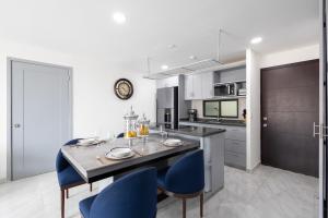 a kitchen with a dining table and blue chairs at Cabo Cove 408 A in Cabo San Lucas