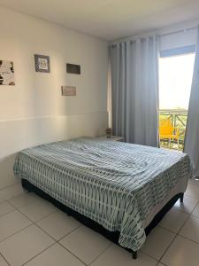 a bedroom with a bed in a room with a window at Flat 1218, no residencial monte castelo in Bezerros