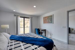 a bedroom with a bed with a blue blanket on it at Cabo Cove 408 A in Cabo San Lucas +16 photos