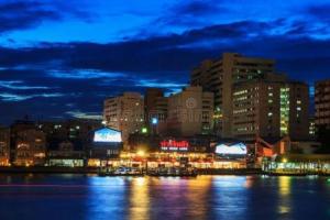 a city lit up at night with buildings and the water at Mimi Cozy Apartment- Oldrown Siriraj Wanglang Market in Bangkok