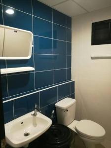 a blue tiled bathroom with a toilet and a sink at Mimi Cozy Apartment- Oldrown Siriraj Wanglang Market in Bangkok