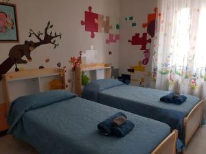 a bedroom with two beds and a puzzle wall at Casa Ellie - casa vacanze con giardino e posto auto privati in Grado