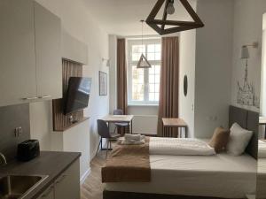 a small room with a bed and a kitchen at Aviendo Old Town Apartments in Wrocław