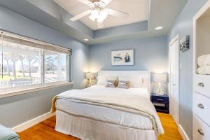 a bedroom with a bed with a ceiling fan and a window at Old Town Treasure in Port Aransas