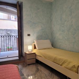 une petite chambre avec un lit et une fenêtre dans l'établissement Il Cortiletto Mountain Lake Iseo Hospitality, à Costa Volpino