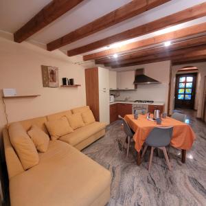 een woonkamer met een bank en een tafel bij Il Cortiletto Mountain Lake Iseo Hospitality in Costa Volpino