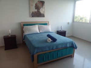 Un dormitorio con una cama azul con un osito de peluche. en Apartamento Cartagena, en Cartagena de Indias