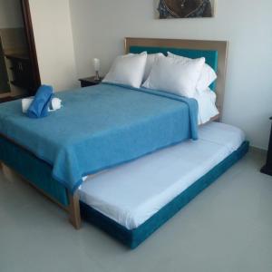 2 camas con sábanas azules y almohadas blancas en un dormitorio en Apartamento Cartagena, en Cartagena de Indias