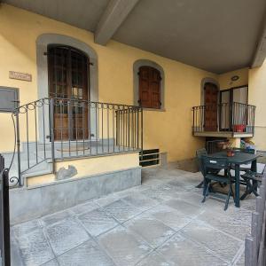 een patio met een tafel en stoelen in een gebouw bij Il Cortiletto Mountain Lake Iseo Hospitality in Costa Volpino